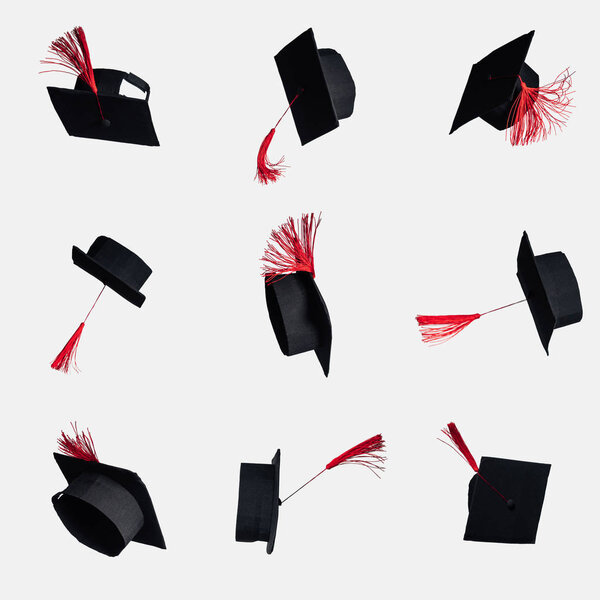 Black academic caps with red tassels isolated on white