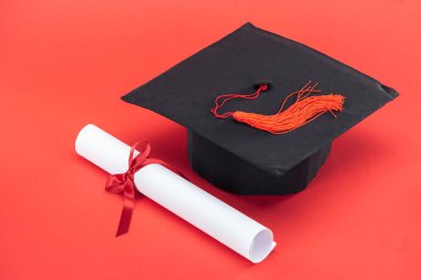 Püskül ve diploma ile kurdele kırmızı yüzeyi ile akademik kap