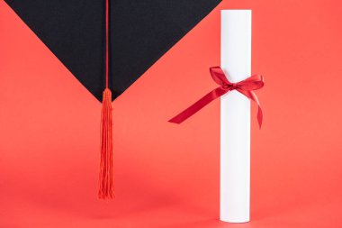 Püskül ve diploma ile kurdele kırmızı yüzeyi ile akademik kap