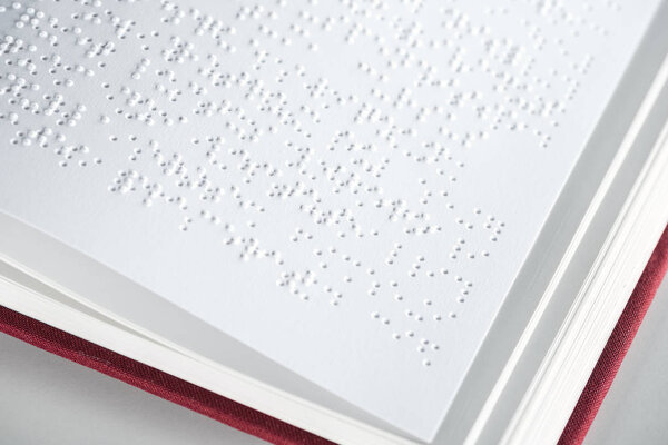 close up view of book with braille text isolated on grey