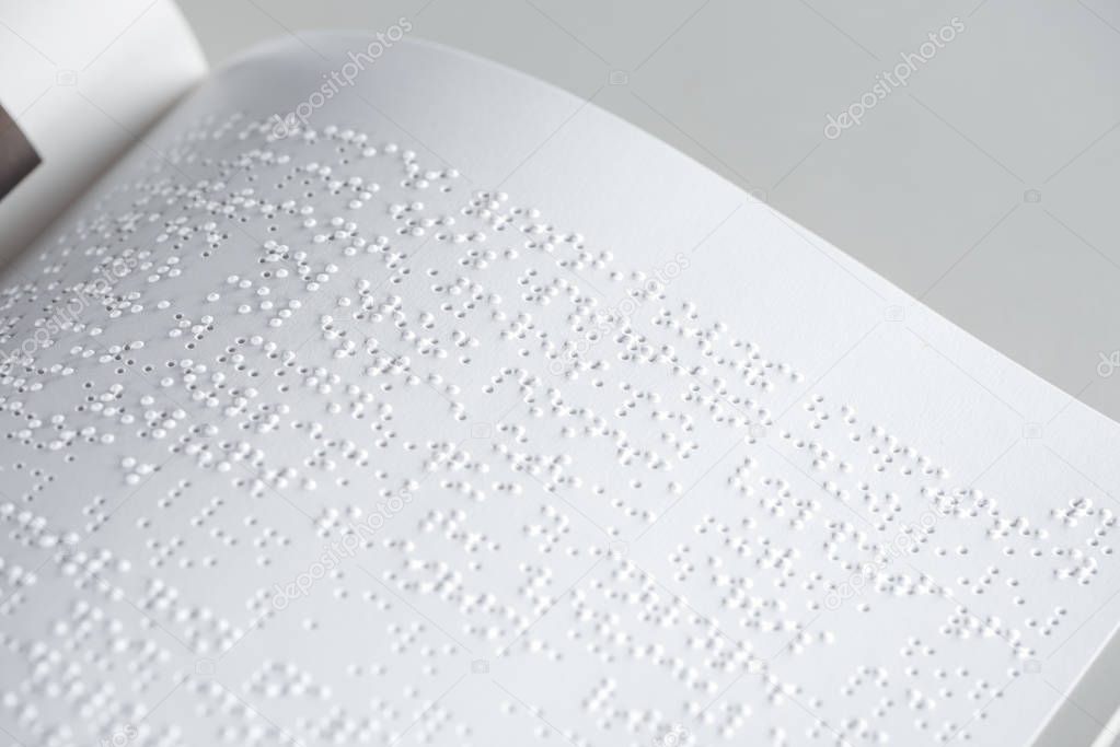 close up view of braille text on white paper isolated on grey