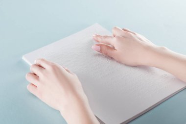 kırpılan genç kadın mavi izole kağıt üzerinde kabartma metin okuma görünümünü