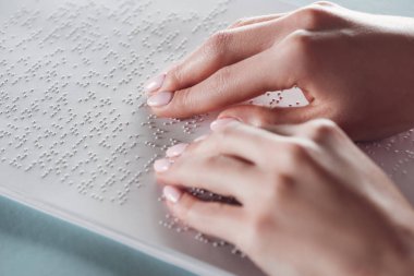 kırpılan kız beyaz kağıt üzerinde elleriyle braille metin okuma görünümünü