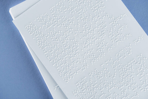 top view of braille text on white paper isolated on violet