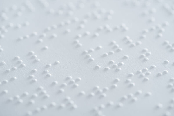 крупный план текста шрифтом Брайля на белой бумаге
