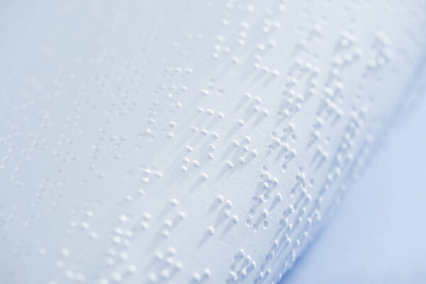 selective focus of text in braille code on white paper with copy space