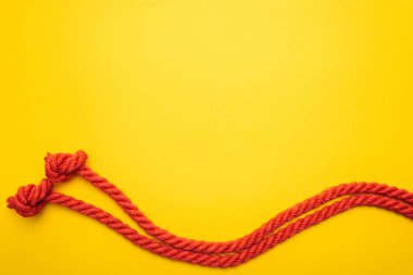 Kırmızı jüt halat üzerinde turuncu izole knot ile el salladı 