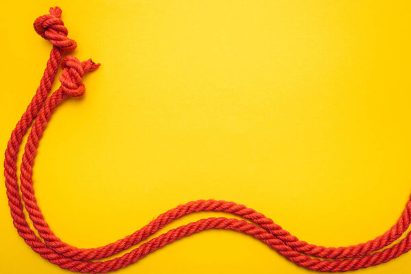 red waved ropes with knots isolated on orange 