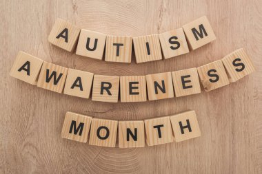 top view of autism awareness month words made of wooden cubes clipart