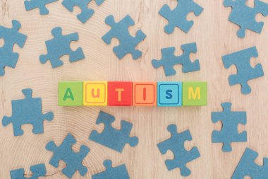 Otizm yazı üstten görünüm çok renkli küpler ahşap masa üzerinde mavi puzzle parçaları arasında yapılan