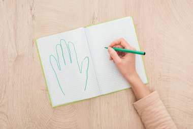 cropped view of female hand on opened notebook near drawn human palm clipart