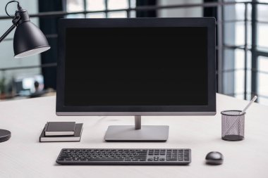 computer monitor with blank screen and stationery at workplace clipart