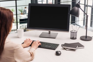 İşyerinde ofiste bilgisayar kullanan kadın seçici odak