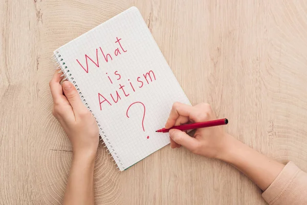 Partial View Woman Writing Notebook What Autism Question Wooden Table — Stock Photo, Image