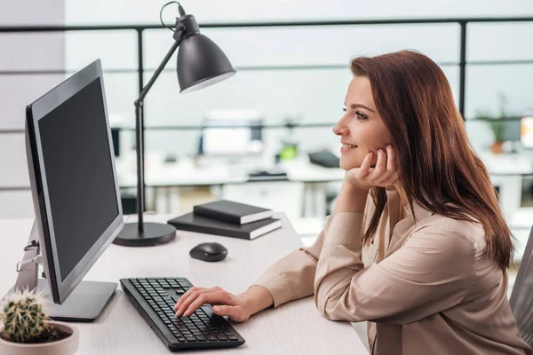 快乐的年轻女子在现代办公室的工作场所在电脑键盘上打字 — 图库照片