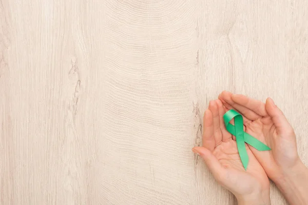 Partial View Woman Holding Green Ribbon Wooden Background — Stock Photo, Image