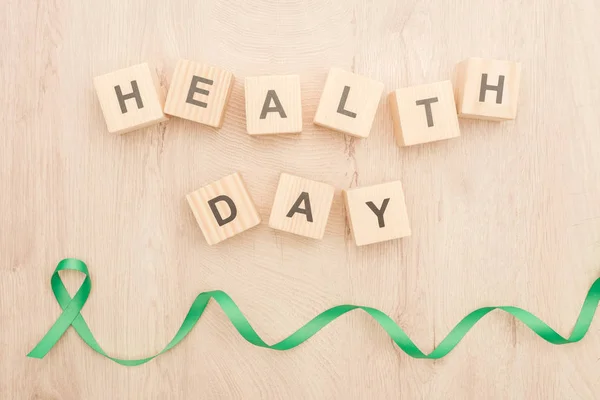 Top View Green Ribbon Cubes Health Day Lettering Wooden Background — Stock Photo, Image