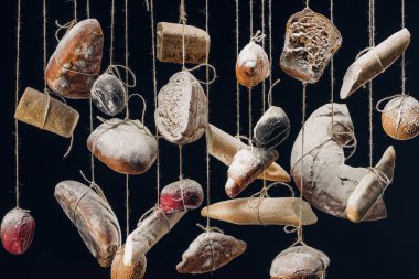 bread with flour hanging on strings isolated on black clipart