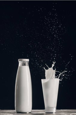 süt cam şişe siyah izole yakınındaki sıçramasına