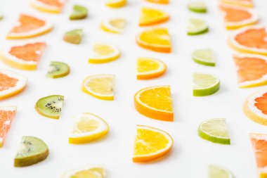 Beyaz yüzeyde sulu taze dilimlenmiş narenciye meyveleri