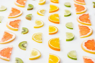 Beyaz yüzeyde sulu taze dilimlenmiş narenciye meyveleri