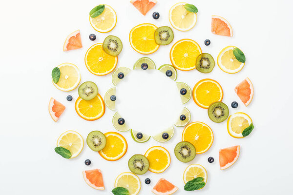 Flat lay with cut fruits and blueberries on white surface