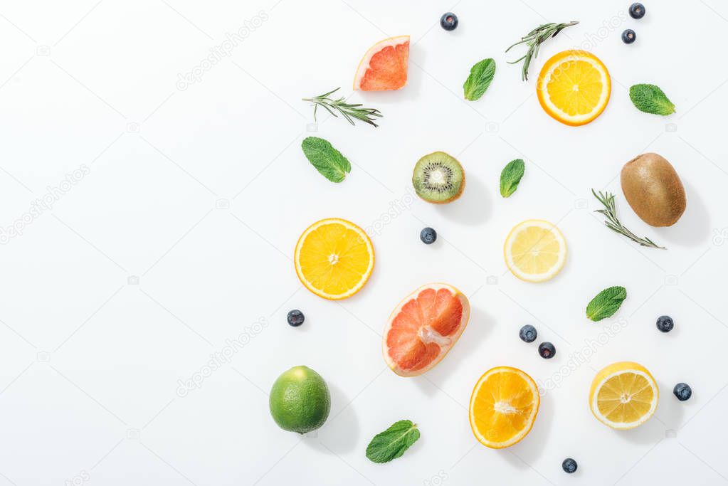 Top view of fresh fruits, rosemary and blueberries on white surface