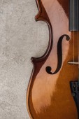 pohled na klasické violoncello na šedé texturované ploše