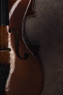 top view of classical cello on grey textured surface in darkness clipart