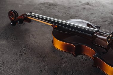 wooden classical violoncello in darkness on textured surface clipart