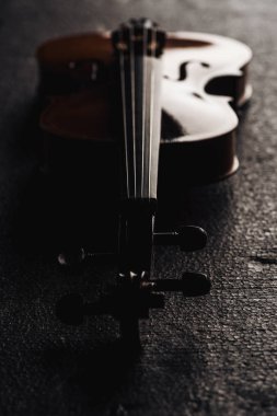 close up of strings on cello in darkness on grey textured background clipart