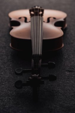 close up of strings on cello in darkness on grey textured surface  clipart