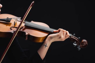 partial view of woman with tattoo playing cello with bow isolated on black clipart