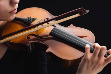 cropped view of woman playing cello with bow isolated on black clipart