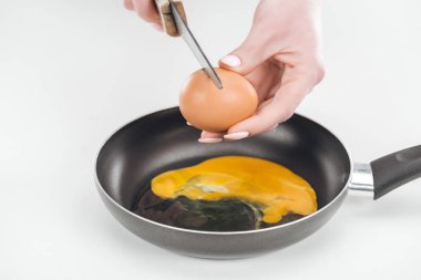 Beyaz arka planda Pan yumurta omlet hazırlarken bıçak ile tavuk yumurtası smashing kadının görünümü kırpılmış