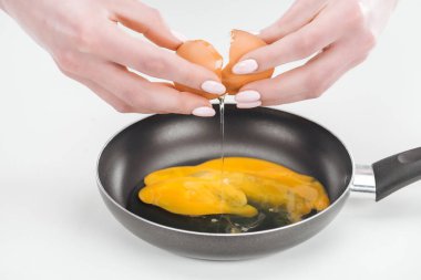 Beyaz arka planda Pan yumurta omlet hazırlarken taze tavuk yumurtası smashing kadın kırpılmış görünümü