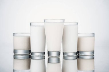 glasses with organic alternative milk on grey background with reflection clipart
