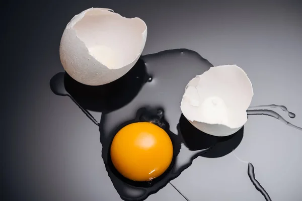 黒の背景に卵黄 たんぱく質 卵殻を使用した新鮮な鶏の卵のクローズアップ — ストック写真