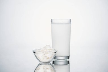 gri arka planda Hindistan cevizi dilimleri ile kase yakın cam Hindistan cevizi vegan süt