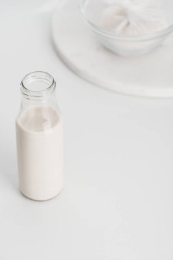 selective focus of rice milk in bottle with rice in cheesecloth on background clipart