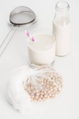 Nohut beyaz larloth şişe ve cam Vegan nohut süt ve elek gri arka planda yakın
