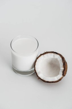gri arka planda Hindistan cevizi yarısını yakın cam organik Vegan Hindistan cevizi sütü