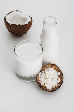 Organik Vegan Hindistan cevizi sütü yakın Hindistan cevizi yarısı ve cips gri arka planda
