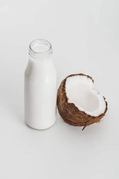 Biologische Veganistische Kokosmelk Fles Buurt Van Kokos Helft Grijze Achtergrond — Stockfoto