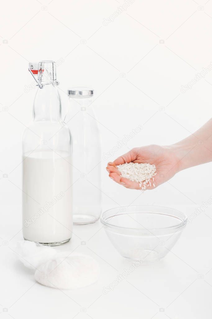 cropped view of woman putting rice in bowl while cooking rice vegan milk