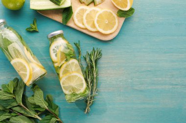limon ve salatalık dilimleri, nane ve biberiye ile şişeleri detoks içecek üst görünümü