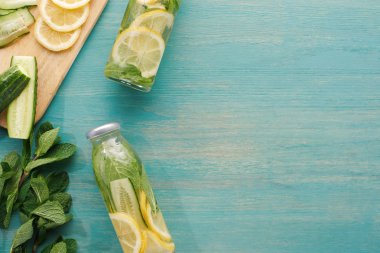 top view of detox drink in bottles with lemon and cucumber slices and mint clipart