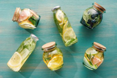 meyveler, sebzeler, otlar, çilek ve yeşillikler ile şişeler ve kavanozlarda Detox içeceklerin üst görünümü