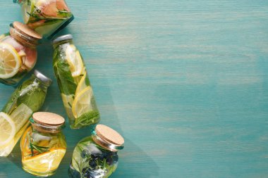 meyveler, sebzeler, otlar, çilek ve yeşillikler ile şişeler ve kavanozlarda Detox taze içeceklerin üst görünümü