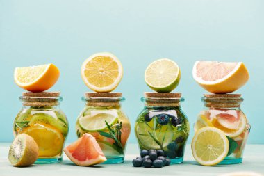 mavi üzerinde izole malzemelerle kavanozlarda taze Detox İçecekler